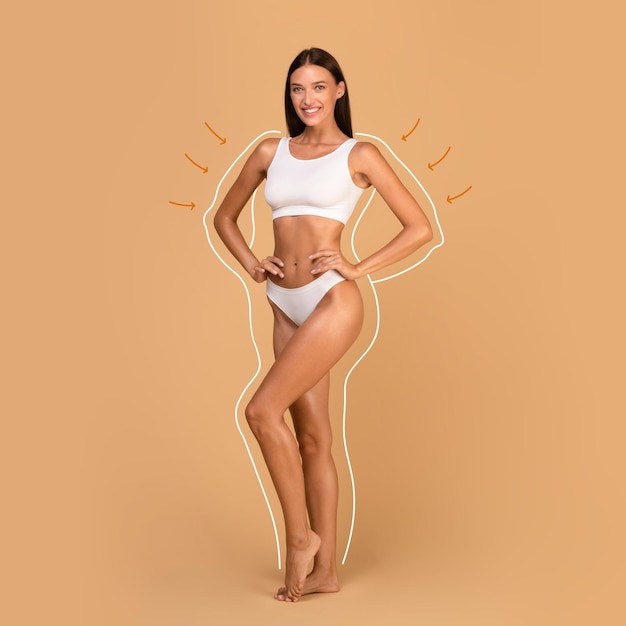 Concepto de cuidado corporal y escultura Modelo femenino en sujetador superior blanco y bragas posando sobre fondo de estudio beige