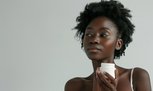 Concepto de cuidado corporal Mujer joven africana positiva que sostiene un producto cosmético de belleza