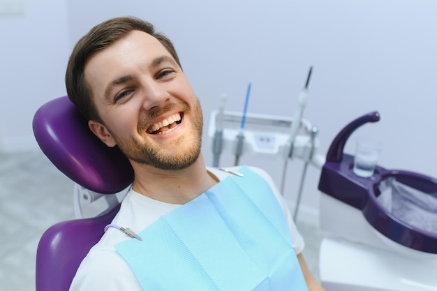 Foto concepto de cuidado dental chico guapo joven en el consultorio del dentista