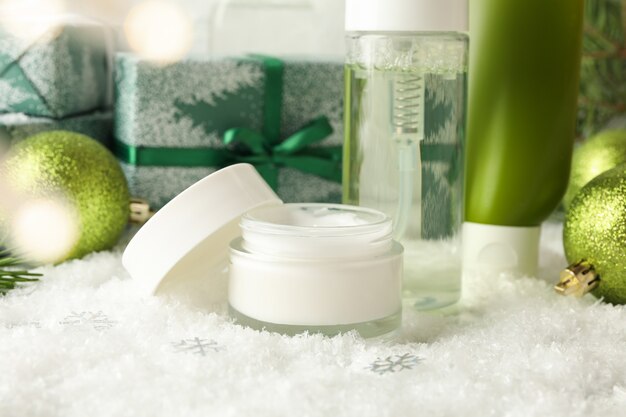 Concepto de cuidado facial con cosméticos sobre fondo con nieve decorativa