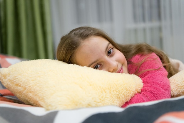 Foto concepto de cuidado infantil. relajación agradable. salud mental y positividad. guiones de meditación y relajación guiados gratuitos para niños. niña pequeña relajarse en casa. relajación vespertina antes de dormir.