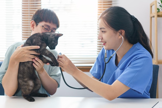 Concepto de cuidado de mascotas estetoscopio de uso veterinario femenino para comprobar el aliento del pequeño gatito en la clínica veterinaria