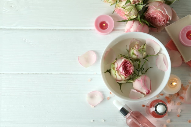 Concepto de cuidado de la piel con aceite esencial de rosa en la mesa de madera blanca