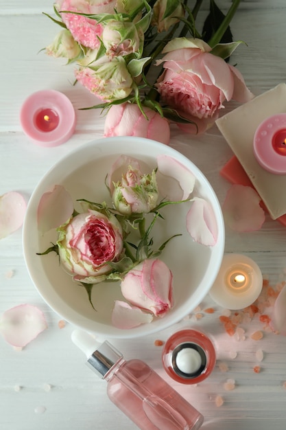 Concepto de cuidado de la piel con aceite esencial de rosa en la mesa de madera blanca