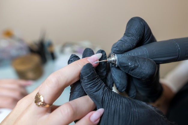 Concepto de cuidado de uñas Manicurist hace una manicura a una chica cliente en un salón de belleza