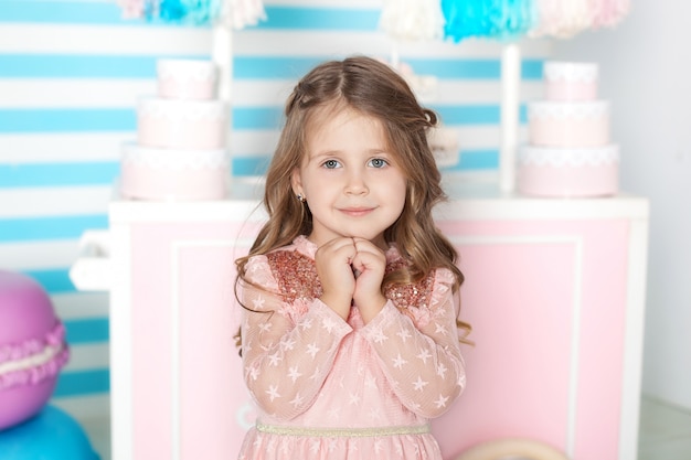 Concepto de cumpleaños y felicidad - niña feliz con dulces