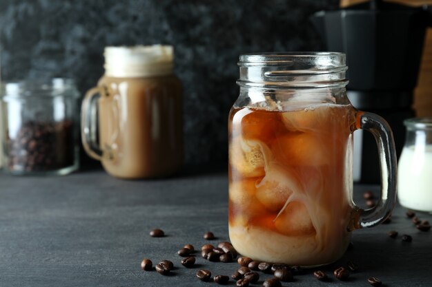 Concepto de deliciosa bebida con café helado en la mesa de madera oscura.