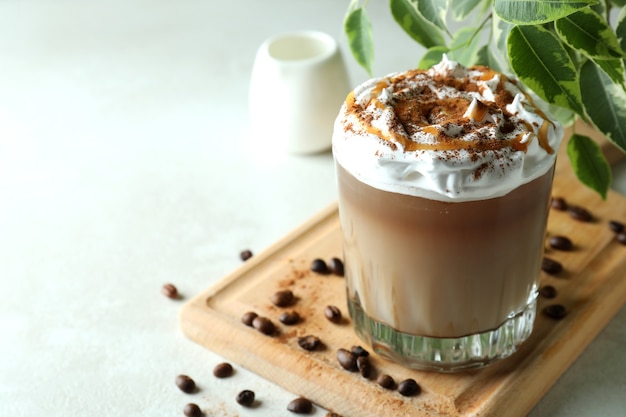 Concepto de deliciosa bebida con café helado en mesa con textura blanca
