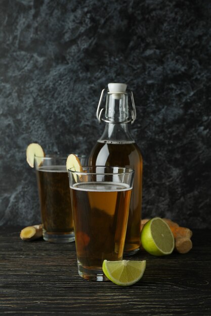 Concepto de deliciosa bebida con vasos y una botella de cerveza de jengibre en la mesa de madera