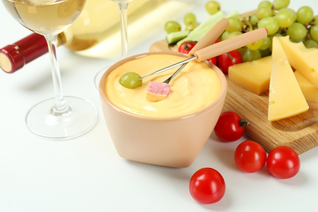 Concepto de deliciosa comida con fondue sobre fondo blanco.
