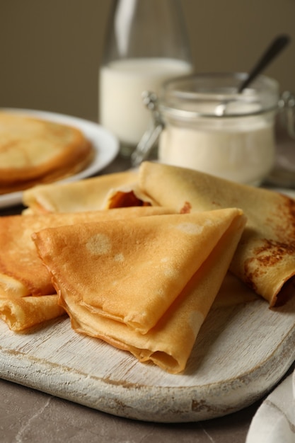 Concepto de delicioso desayuno con tortitas finas en mesa gris