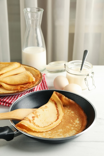 Foto concepto de delicioso desayuno con tortitas finas en mesa de madera blanca