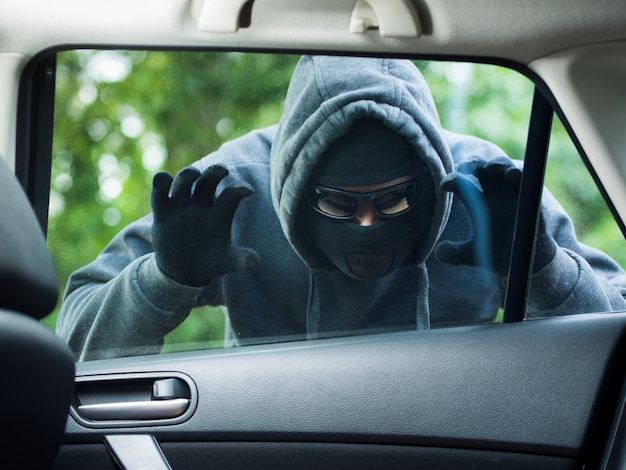 Concepto de delito de transporte ladrón robando la bolsa del coche