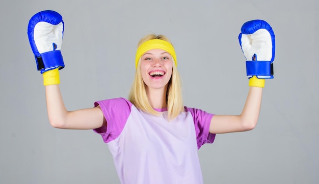 Concepto de deporte de boxeo. Ejercicios de cardio boxing para adelgazar. Feminidad y equilibrio de fuerza. Los guantes de boxeo de mujer disfrutan del entrenamiento. Niña aprende a defenderse. Mujer haciendo ejercicio con guantes de boxeo.