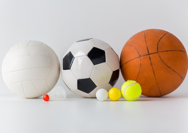 Foto concepto de deporte, fitness, juego, equipo deportivo y objetos - cierre de diferentes balones deportivos y volante