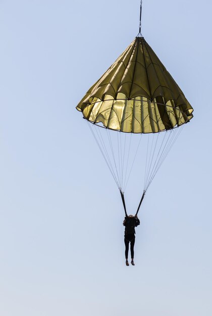 Foto concepto de deporte de paracaídas paracaidista que desciende con un paracaídas