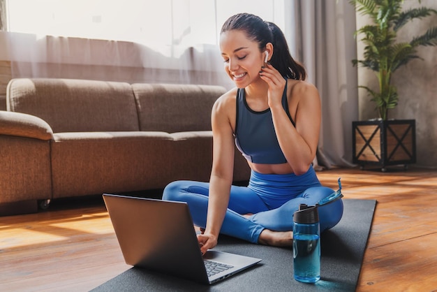 Foto concepto de deporte y recreación mujer deportiva en ropa deportiva y auriculares trabajando