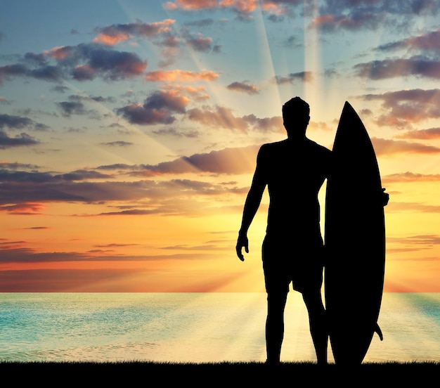 Concepto de deporte. Silueta de surfistas contra el mar en la noche