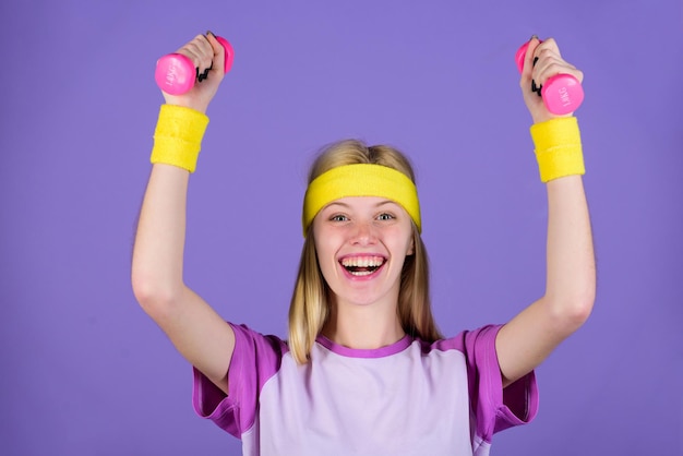 Concepto de deporte vintage Mujer haciendo ejercicio con mancuernas Ejercicios fáciles con mancuernas Entrenamiento con mancuernas Último entrenamiento de la parte superior del cuerpo para mujeres Chica sostenga mancuernas use pulseras brillantes