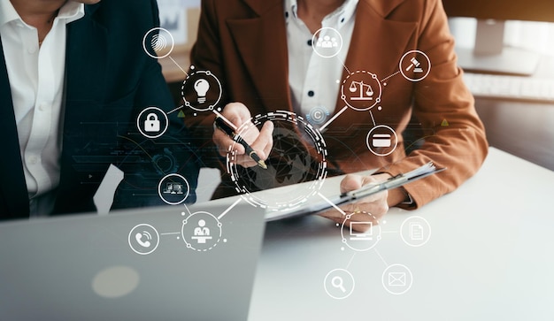 Concepto de derechos de autor o patentes Mano de la persona que usa una computadora portátil, una tableta y un teléfono inteligente con una pantalla virtual icono de derechos de autor marca comercial Creación de propiedad contra la piratería en la oficina