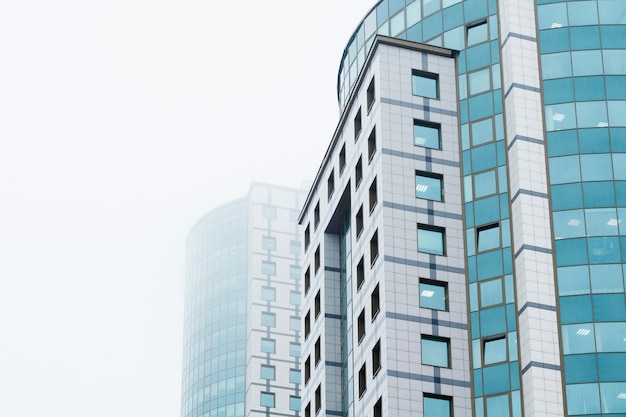 El concepto de desarrollo, éxito, liderazgo, negocios, trabajo de oficina, construcción. Dos edificios de oficinas en la niebla.