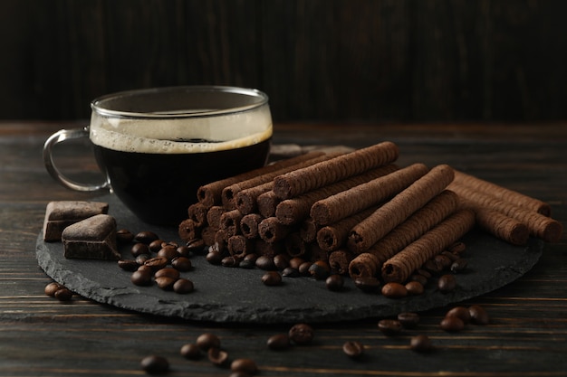 Concepto de desayuno con café y rollos de obleas de chocolate en madera