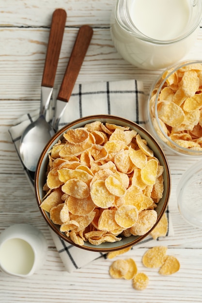 Concepto de desayuno con muesli y leche en la mesa de madera blanca