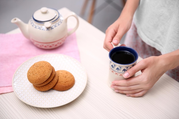 Concepto de desayuno Mujer con taza de té en la cocina