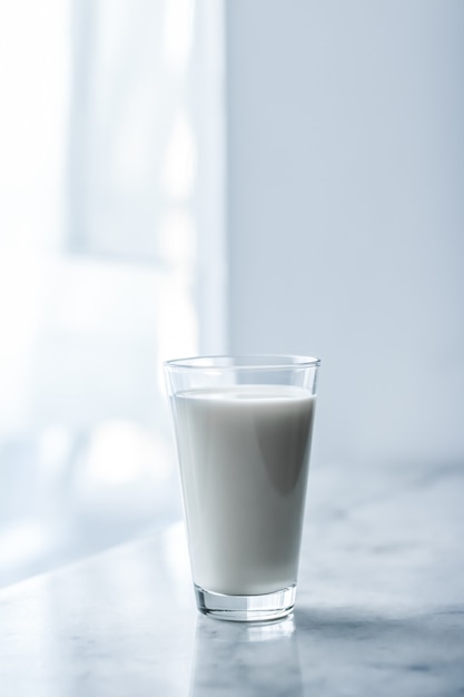 Concepto de desayuno y nutrición saludable de productos lácteos día mundial de la leche vaso lleno sobre mesa de mármol