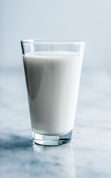 Concepto de desayuno y nutrición saludable de productos lácteos día mundial de la leche vaso lleno sobre mesa de mármol
