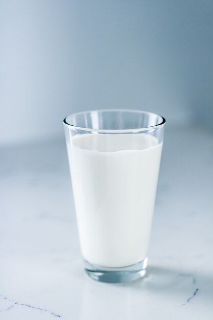 Concepto de desayuno y nutrición saludable de productos lácteos día mundial de la leche vaso lleno sobre mesa de mármol