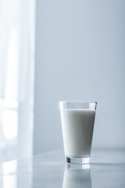 Concepto de desayuno y nutrición saludable de productos lácteos día mundial de la leche vaso lleno sobre mesa de mármol