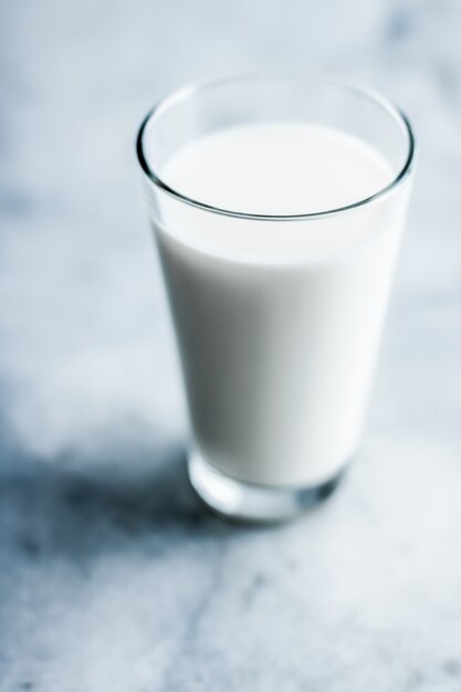 Concepto de desayuno y nutrición saludable de productos lácteos día mundial de la leche vaso lleno sobre mesa de mármol