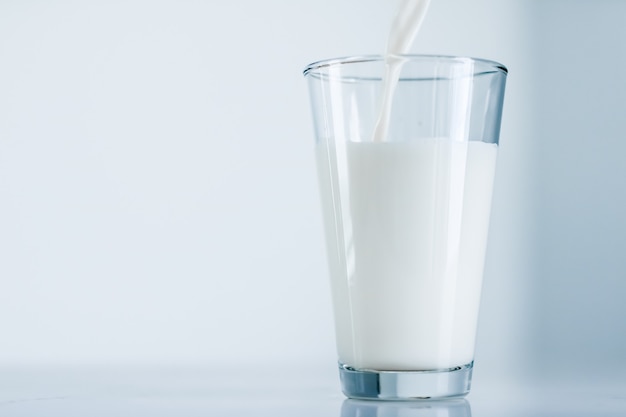 Concepto de desayuno y nutrición saludable de productos lácteos día mundial de la leche verter en vidrio sobre mesa de mármol