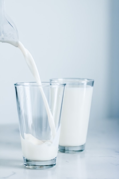 Concepto de desayuno y nutrición saludable de productos lácteos día mundial de la leche verter en vidrio sobre mesa de mármol