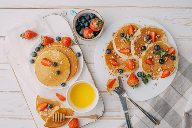 Concepto de desayuno de panqueques con miel y frutos secos.