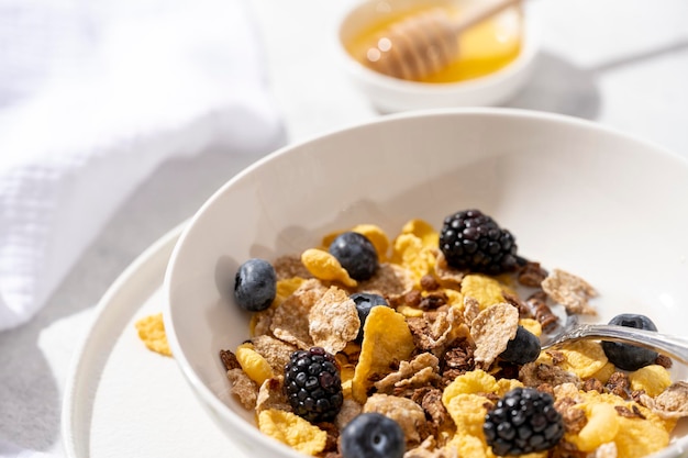 Concepto de desayuno saludable con copos de avena y bayas frescas sobre fondo blanco.