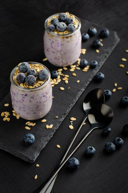 Concepto de desayuno saludable Tarros de yogurt casero con arándanos y avena