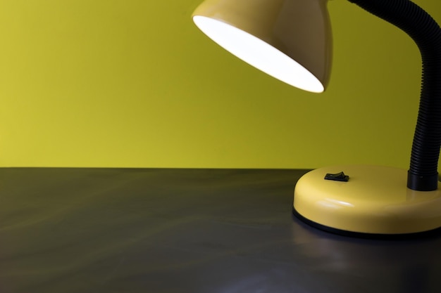 Concepto de detalle de mesita de noche con espacio para copiar y una lámpara encendida