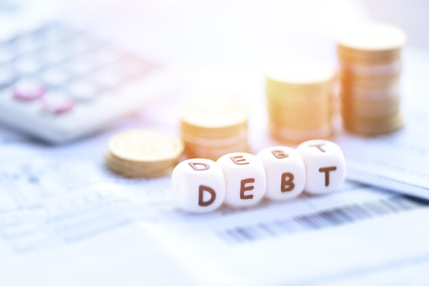 Concepto de deuda con pila de monedas en la calculadora en el papel de la factura Aumento de los pasivos por la exención Consolidación de la deuda de la crisis financiera