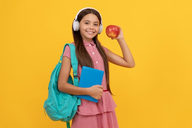 Concepto de día del conocimiento de regreso a la escuela de niño de educación en auriculares con libro de trabajo y manzana