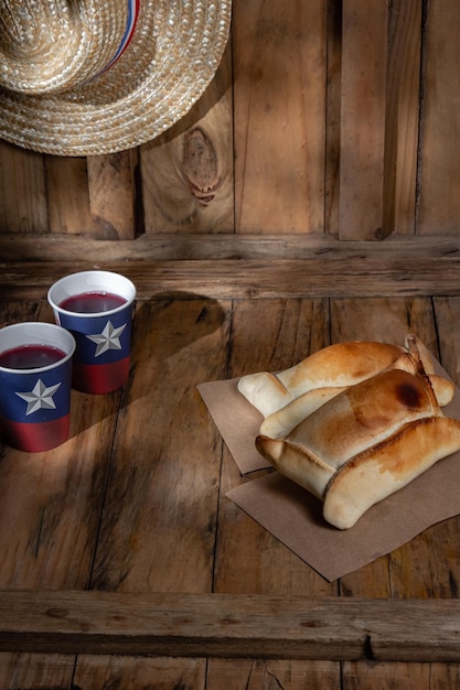 Foto concepto del día de la independencia chilena fiestas patrias típicas empanadas horneadas de pino vino o sombrero chicha