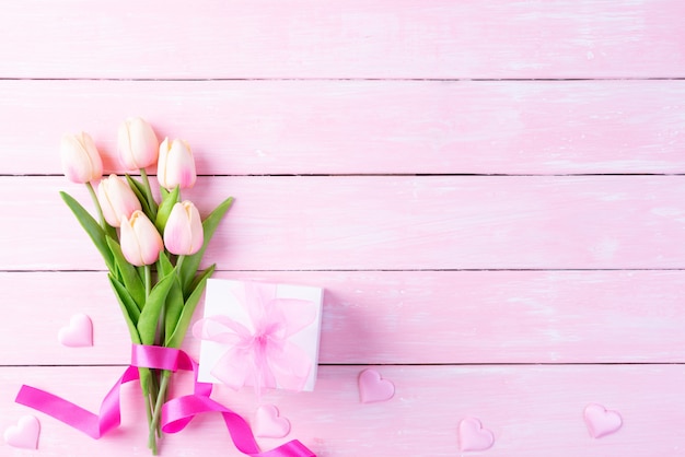 Concepto del día internacional de la mujer. Tulipanes rosa y corazón rojo con caja de regalo.
