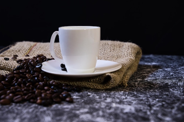 Concepto del día mundial del café taza de porcelana blanca con granos de café