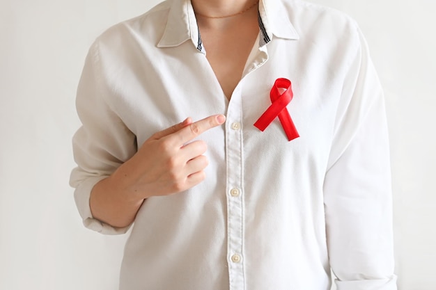 Concepto Día mundial del SIDA y el VIH Mujer con camisa blanca con cinta roja Transfusión de sangre Día de la hemofilia