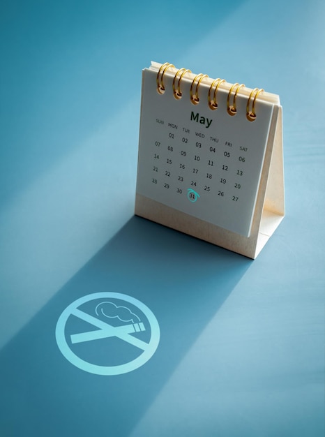 Concepto del Día Mundial sin Tabaco Forma de icono plano de no fumar que brilla en el fondo azul a la sombra de la página de mayo de 2023 en un pequeño calendario de escritorio con una marca de círculo azul claro el día 31 de mayo vertical