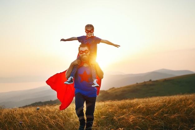 Concepto del día del padre padre e hija disfrazados de héroe superhéroe al atardecer