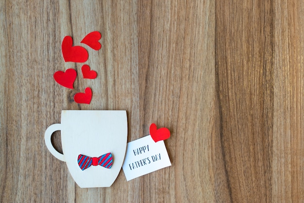 Concepto del día de padres. Taza decorativa con pajarita de papel y corazones.