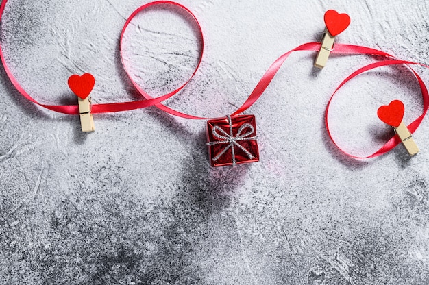 El concepto del día de San Valentín. Caja de regalo con cinta roja y corazones.