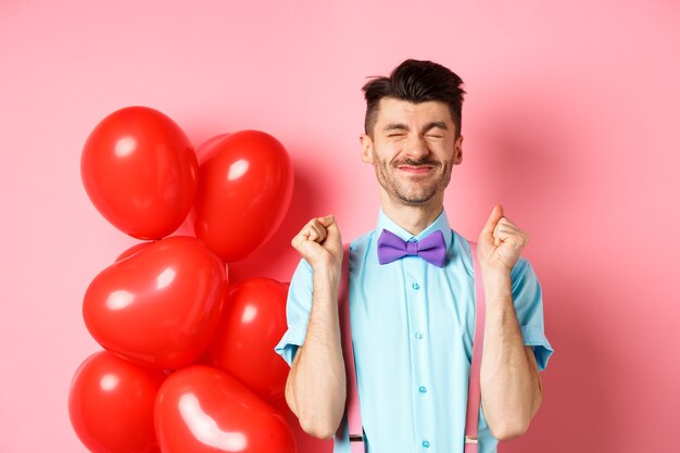 Concepto de día de San Valentín. Chico alegre saltando de emoción antes de cita romántica